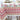 Dining table with a patterned tablecloth, plates, and a vase of flowers.