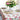 Decorative table setting with floral centerpiece and patterned tablecloth.