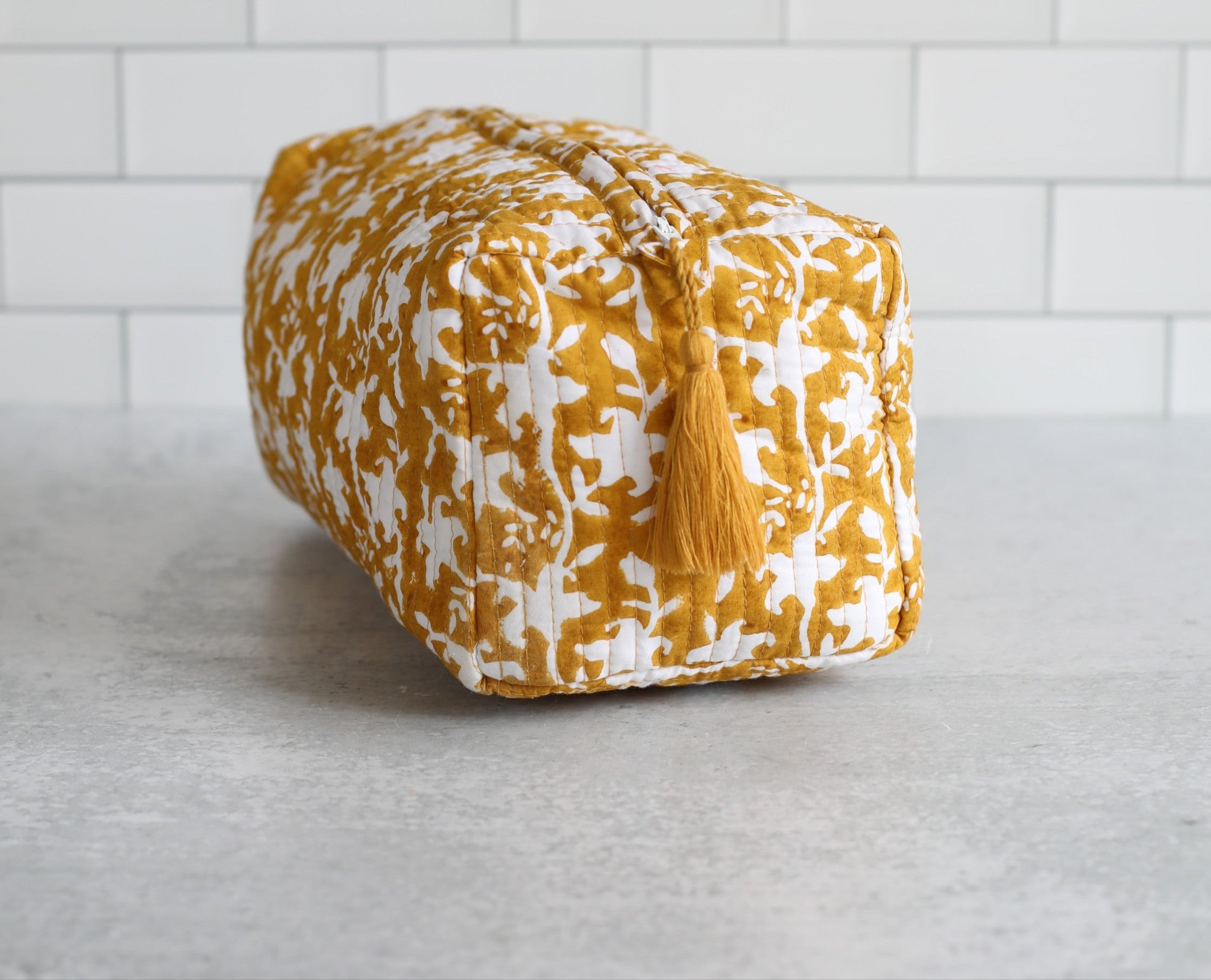 Our Pacho Slate print brings understated elegance to any setting with its swirling floral motif, hand block printed in a sophisticated slate-gray hue on crisp white cotton. The simplified one-color palette highlights the timeless design, making it versatile enough for everyday use or special occasions. Crafted with care by artisans in Jaipur, this print blends tradition with modern style.