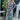 Woman wearing a colorful floral dress standing outdoors.