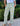 Person wearing green floral pants standing outdoors with plants in the background
